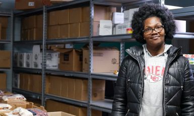 A woman standing in a food pantry.