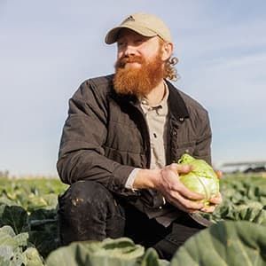 Farmer Mike holds a cabbage.